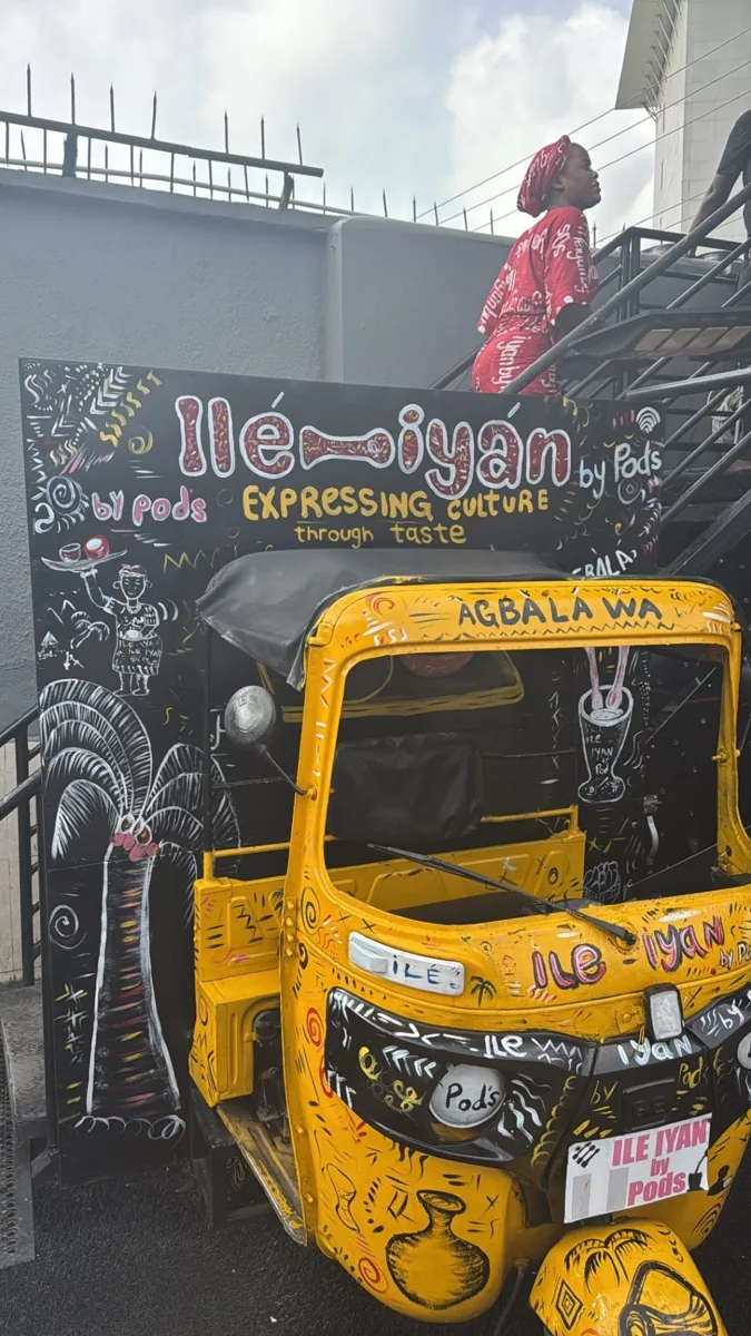 Hand-painted yellow keke outside Ile-Iyan by Pods